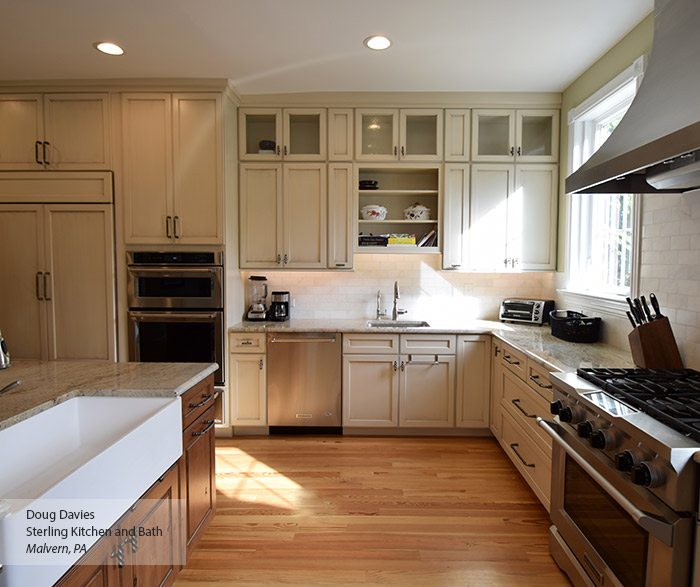 Casual kitchen with off white glazed cabinets and a dark kitchen island